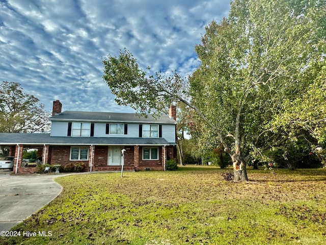 view of front of property featuring a front yard and a carport