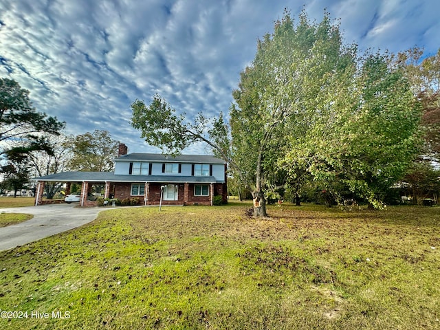 view of front facade with a front lawn and a carport