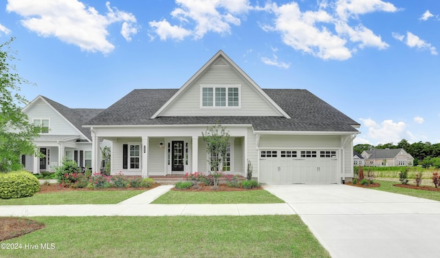 view of front of property featuring a front lawn, a porch, and a garage