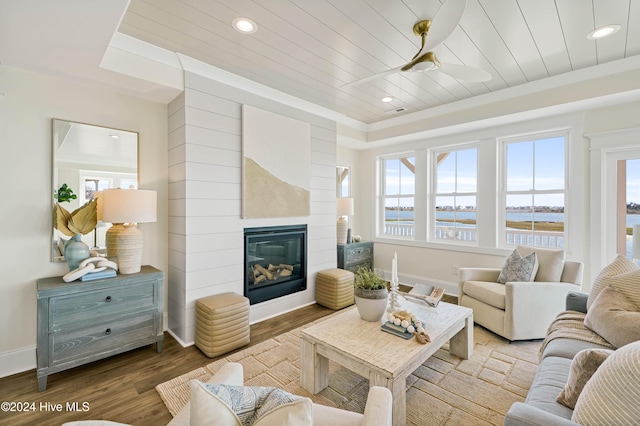 living room featuring ornamental molding, a fireplace, wood ceiling, hardwood / wood-style floors, and a water view