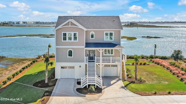 front of property featuring a garage, a water view, and covered porch