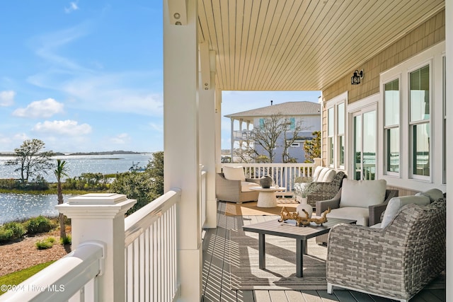 balcony featuring a water view and an outdoor living space