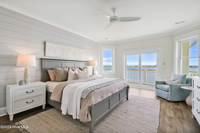 bedroom with dark hardwood / wood-style flooring, access to outside, multiple windows, and ceiling fan