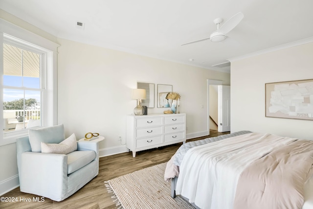 bedroom featuring hardwood / wood-style flooring, ceiling fan, and crown molding