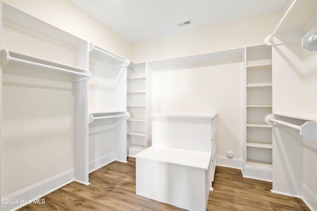 walk in closet with hardwood / wood-style flooring