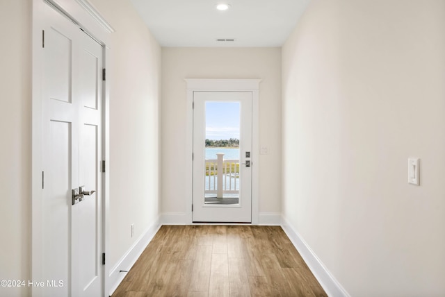 doorway featuring light wood-type flooring and a water view