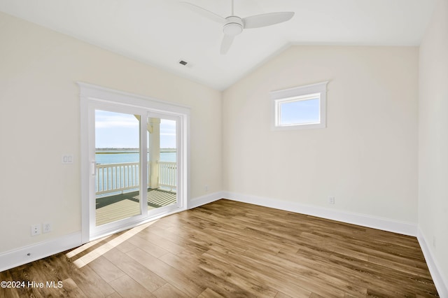 unfurnished room with ceiling fan, wood-type flooring, a water view, and vaulted ceiling