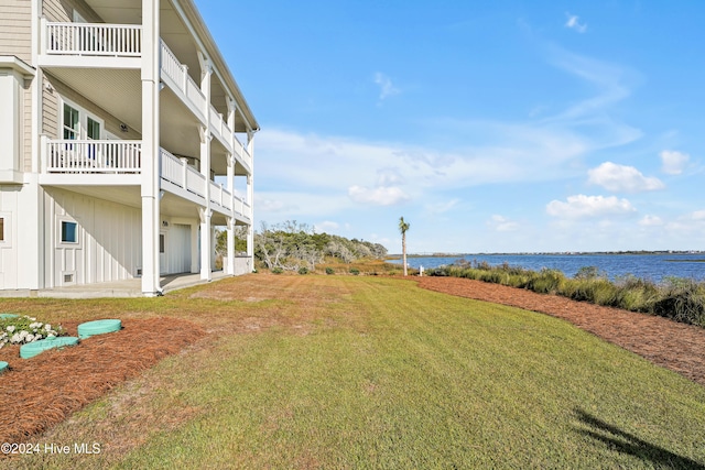 view of yard with a water view and a balcony