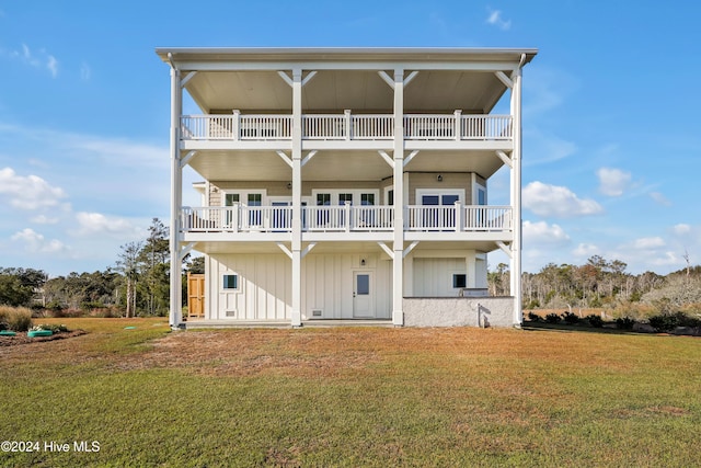 back of property featuring a balcony and a yard