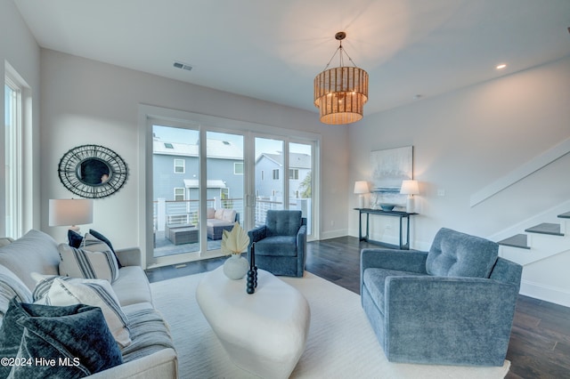 living room with dark wood-type flooring, an inviting chandelier, and plenty of natural light