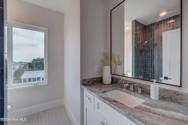 bathroom with vanity and a tile shower