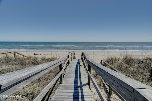 view of property's community with a beach view and a water view