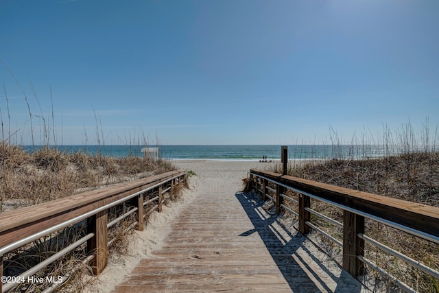 view of dock featuring a view of the beach and a water view