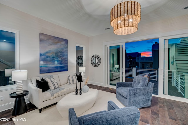 living room featuring wood-type flooring and an inviting chandelier