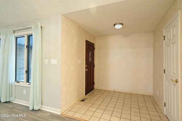 hallway featuring light hardwood / wood-style flooring and a textured ceiling