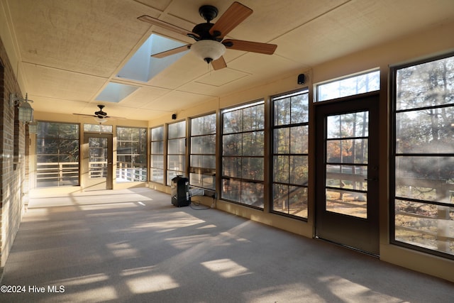 unfurnished sunroom featuring a skylight and ceiling fan