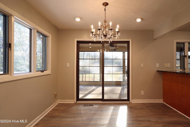 entryway featuring a textured ceiling, ceiling fan with notable chandelier, and dark wood-type flooring