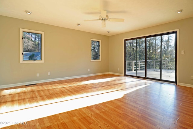 empty room with ceiling fan and hardwood / wood-style floors