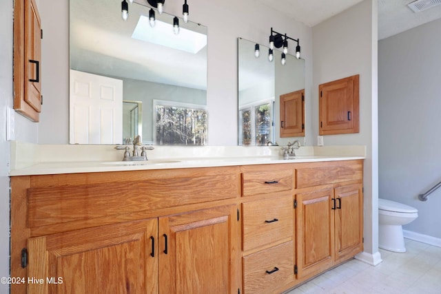 bathroom with vanity, a shower with shower door, and toilet