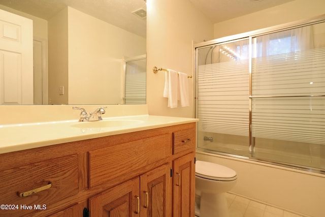 full bathroom featuring vanity, toilet, and shower / bath combination with glass door