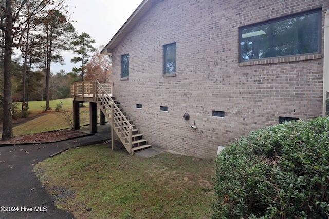 view of side of property with a lawn and a wooden deck