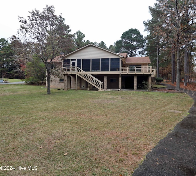 rear view of property with a sunroom, a deck, and a lawn