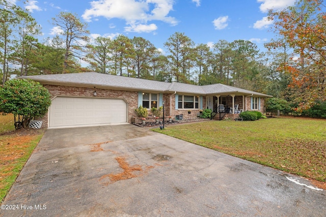 ranch-style house featuring a garage, a front lawn, and covered porch