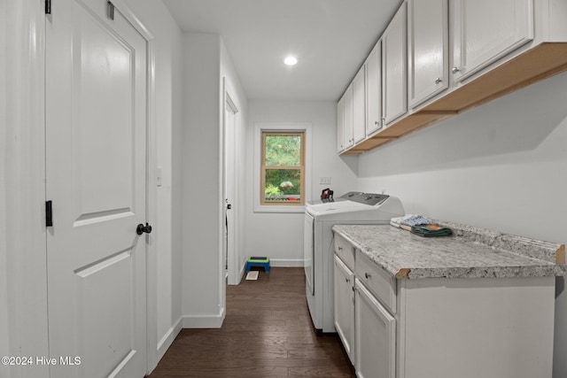 laundry area featuring dark wood-type flooring, cabinets, and washer and dryer