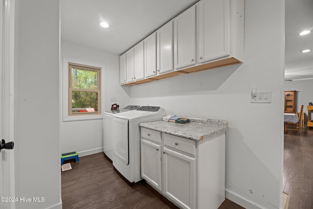 clothes washing area with dark wood-type flooring, cabinets, and washer and clothes dryer