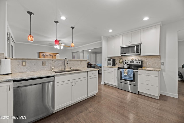 kitchen featuring appliances with stainless steel finishes, dark hardwood / wood-style flooring, hanging light fixtures, sink, and white cabinets