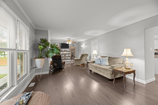 living room featuring dark wood-type flooring, ceiling fan, and crown molding