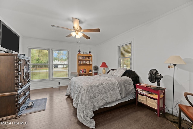 bedroom with ornamental molding, dark wood-type flooring, and ceiling fan