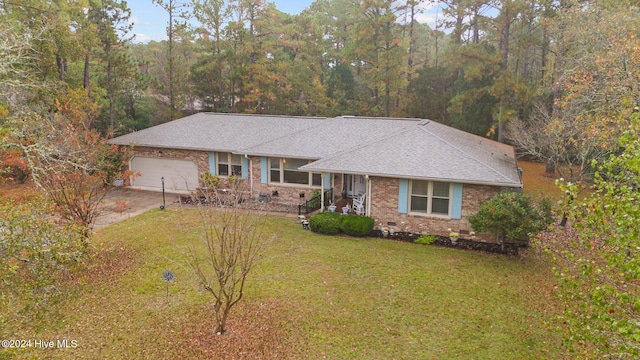 ranch-style house featuring a garage and a front lawn