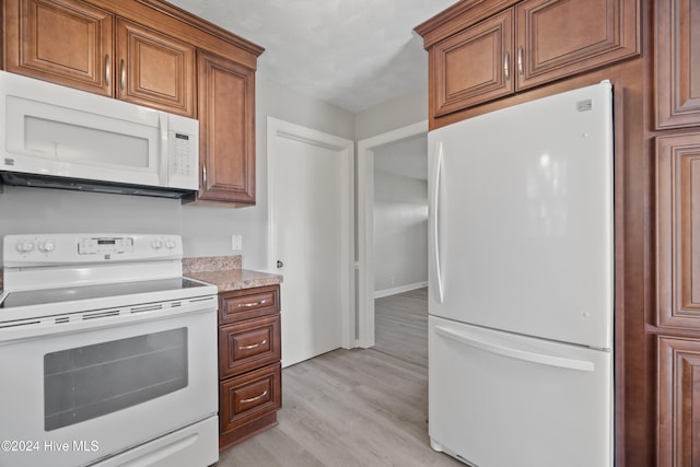 kitchen featuring white appliances and light hardwood / wood-style flooring