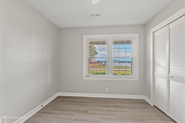 unfurnished bedroom with a closet and light wood-type flooring