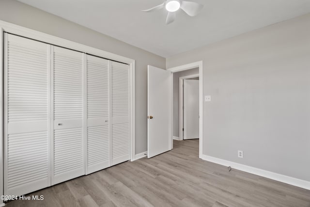 unfurnished bedroom featuring ceiling fan, light hardwood / wood-style floors, and a closet