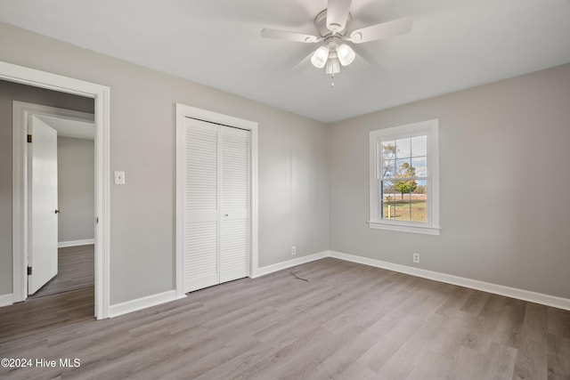 unfurnished bedroom featuring ceiling fan, light wood-type flooring, and a closet