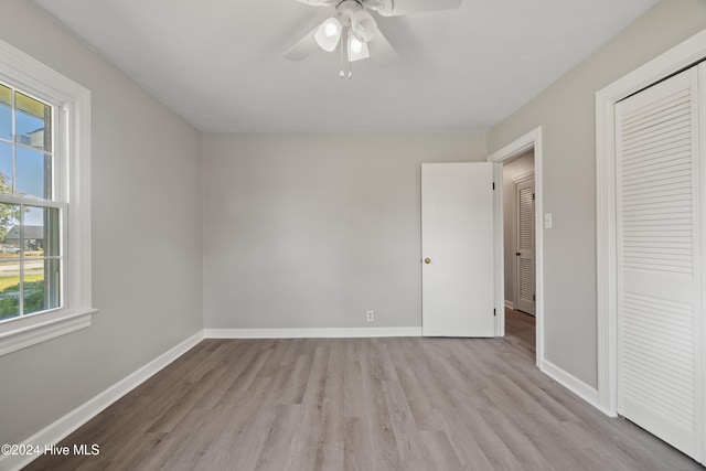 unfurnished bedroom with ceiling fan, light hardwood / wood-style floors, and a closet