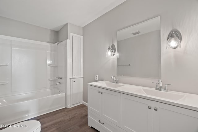 full bathroom with bathing tub / shower combination, hardwood / wood-style floors, vanity, and toilet