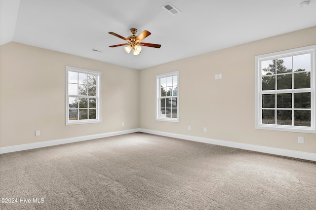 unfurnished room with ceiling fan, plenty of natural light, lofted ceiling, and carpet