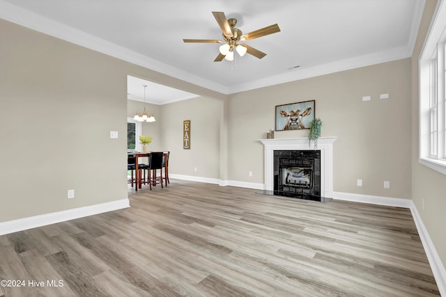 unfurnished living room featuring hardwood / wood-style floors, a premium fireplace, and ornamental molding