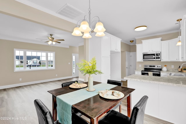 dining space featuring ornamental molding, ceiling fan with notable chandelier, light hardwood / wood-style flooring, and sink