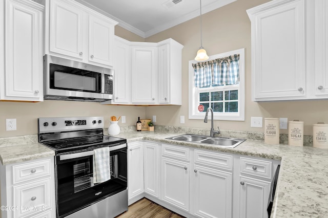 kitchen featuring stainless steel appliances, white cabinets, hanging light fixtures, sink, and ornamental molding