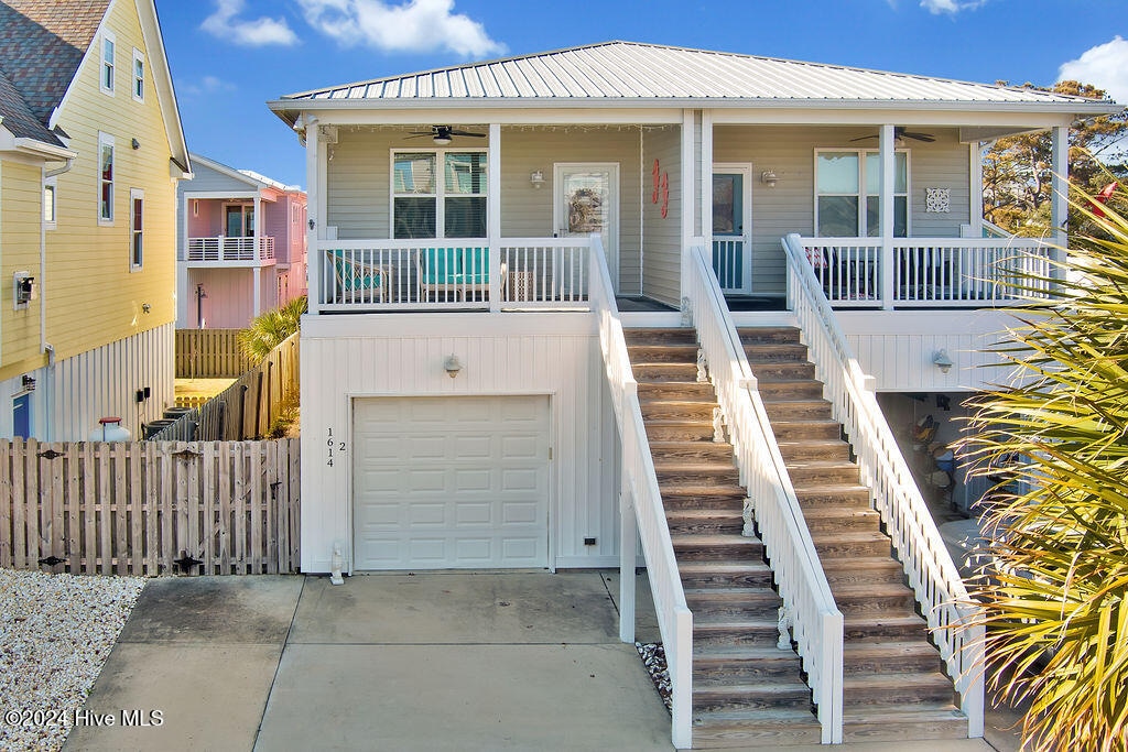 view of front of home featuring a garage, ceiling fan, and a porch