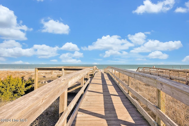 dock area with a water view and a view of the beach