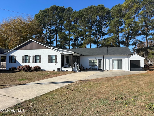 single story home featuring an outbuilding, a front yard, and a garage