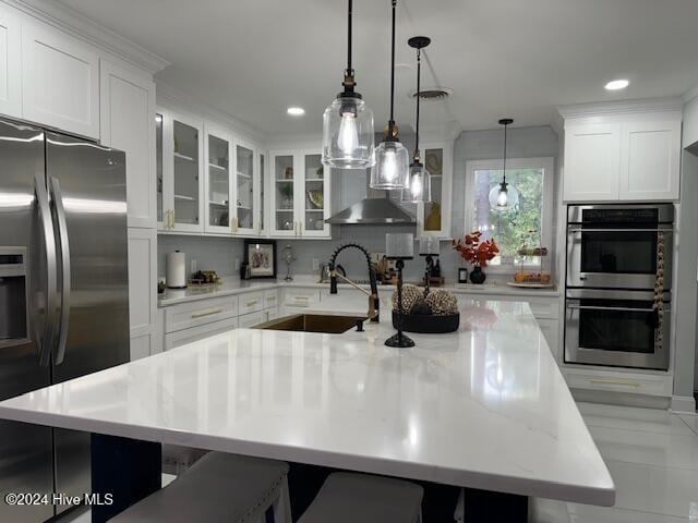 kitchen with white cabinets, decorative light fixtures, stainless steel appliances, and sink