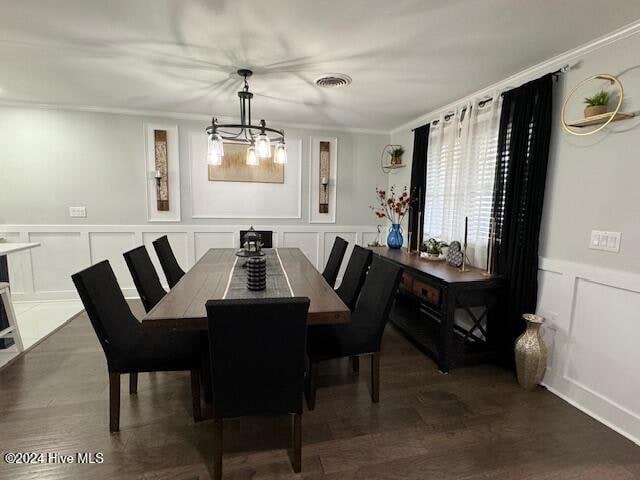 dining room with a chandelier, ornamental molding, and dark wood-type flooring