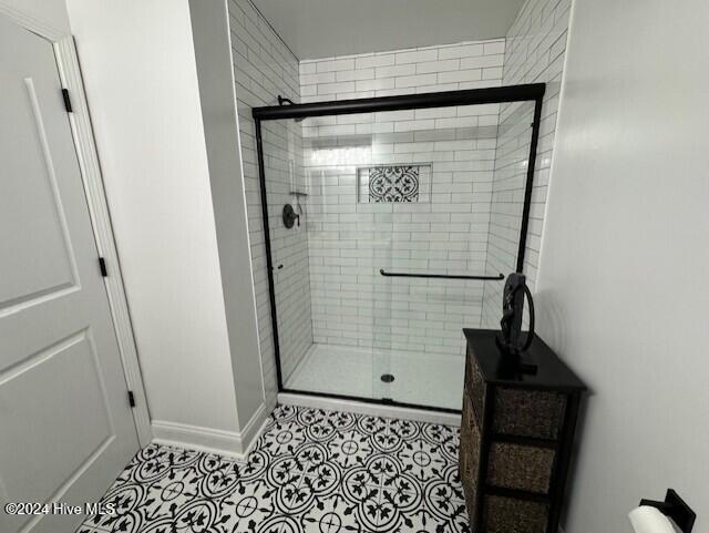 bathroom with tile patterned flooring and walk in shower