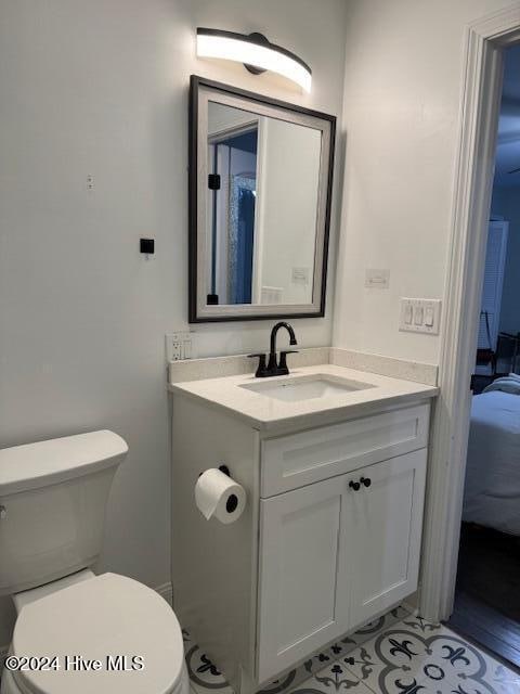 bathroom with tile patterned flooring, vanity, and toilet